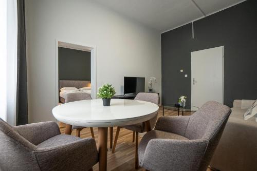 a dining room with a white table and chairs at Bright apartment 15 min from the city center in Vienna