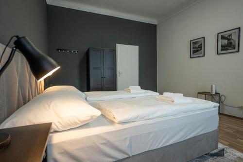 a bedroom with two white beds and a lamp at Bright apartment 15 min from the city center in Vienna