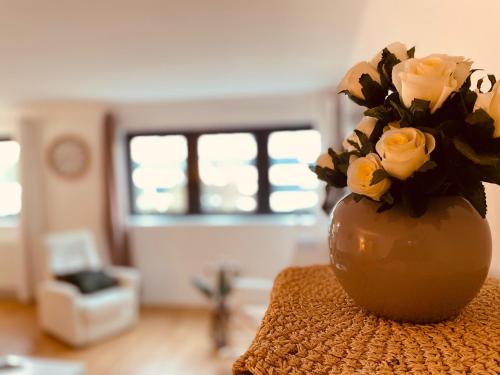 un vase rempli de roses jaunes assis sur une table dans l'établissement Un moment familial - 279, à Rouen