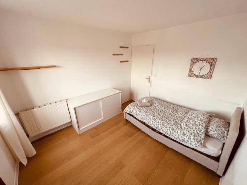 - une petite chambre avec un lit et du parquet dans l'établissement Un moment familial - 279, à Rouen