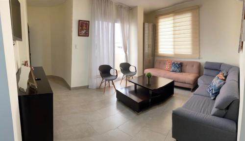 a living room with a couch and two chairs at GARZOTA SUITE DEL ARTE 3er Piso in Guayaquil