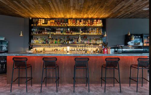 a bar with four bar stools in a room at Percent Hotel Yangshuo in Yangshuo