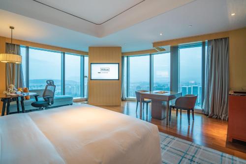 a hotel room with a bed and a table and chairs at Hilton Fuzhou in Fuzhou
