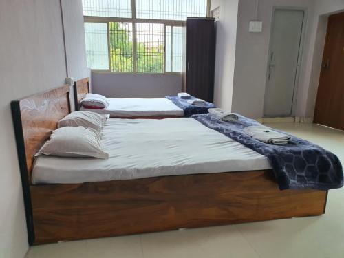 two twin beds in a room with at Hotel Family Stay in Aurangabad