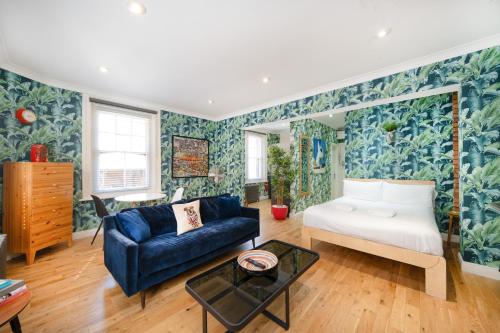 a living room with a couch and a bed at Crashpads Shoreditch Apartments - Brick Lane Mini Lofts in London