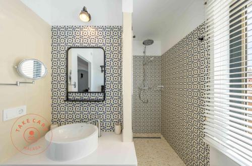 ein Badezimmer mit einem Waschbecken, einem Spiegel und einer Badewanne in der Unterkunft Stylish apartment in Malaga Centro - TCM in Málaga