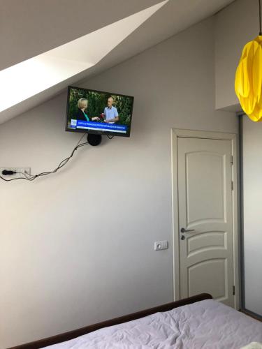 a flat screen tv on a wall in a bedroom at Misko Apartaments in Kaunas