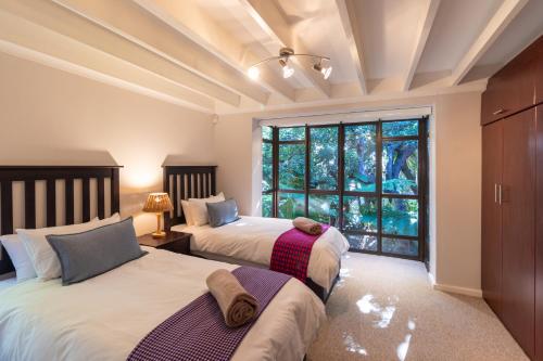 um quarto com 2 camas e uma grande janela em Heart of Wilderness - 250m from beach - Sleeps 6 em Wilderness