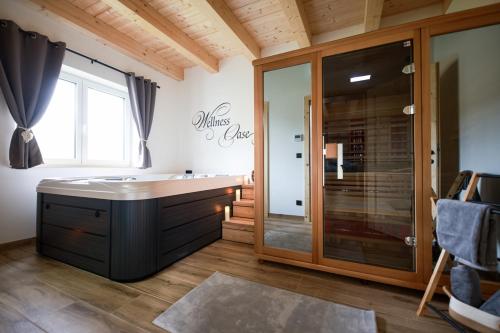 a bathroom with a tub and a glass shower at Sonnendörfl in Poppendorf im Burgenland
