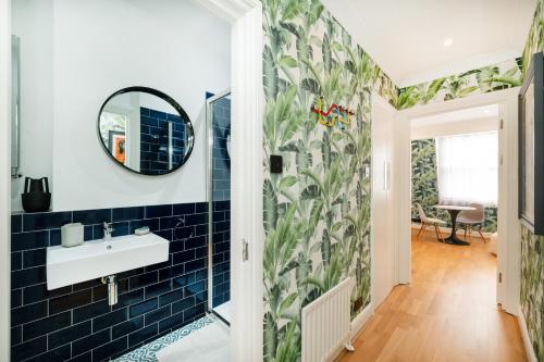 a bathroom with a sink and a mirror at Crashpads Shoreditch Apartments - Brick Lane Mini Lofts in London
