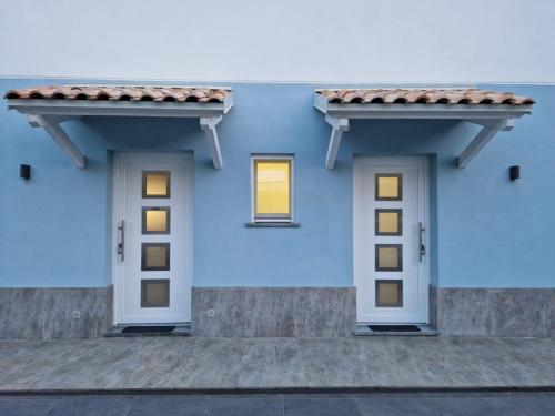 ein blaues Haus mit zwei Fenstern und einem Dach in der Unterkunft Casa Marx in Sedriano