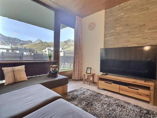 a bedroom with a large television and a large window at Appartement 6 personnes - 1 chambre - 4 lits - Netflix & wifi haut débit - Parking couvert in Tignes
