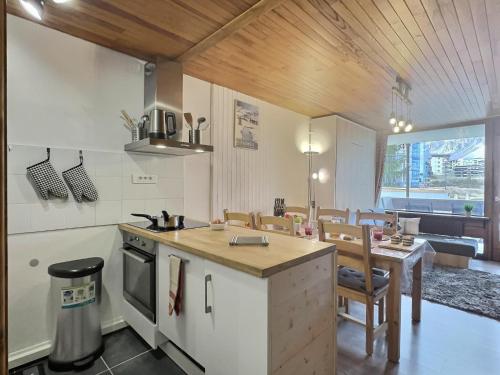 une cuisine avec une table et un comptoir dans l'établissement Appartement Tignes 2100 - 4-6 personnes - 1 chambre - 4 lits - Netflix & wifi haut débit - Parking couvert inclus, à Tignes