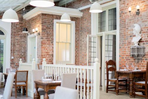 a patio with tables and chairs and a brick wall at Winchester Royal Hotel in Winchester