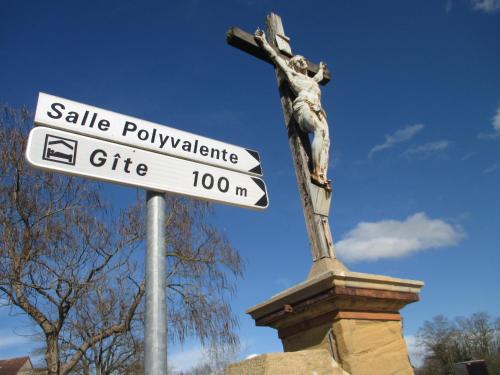 a statue of a cross and a street sign at Le Baugyte - Gite de GROUPE - 14 lits simples in Marcigny