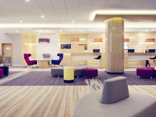 a lobby with chairs and a table and a pillar at Mercure Gdynia Centrum in Gdynia