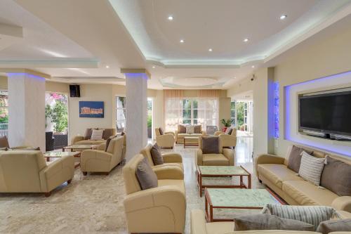 a waiting room with couches and a flat screen tv at Nirvana Beach Hotel in Theologos
