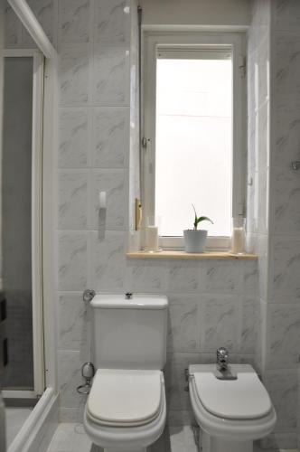 een witte badkamer met een toilet en een raam bij Quevedo Suites 2 - Totalmente equipado al lado de San Marcos - Toallas, Wifi y mucho mas in León