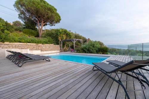une terrasse avec deux chaises et une piscine dans l'établissement Villa Kallisté piscine chauffée, à Serra-di-Ferro