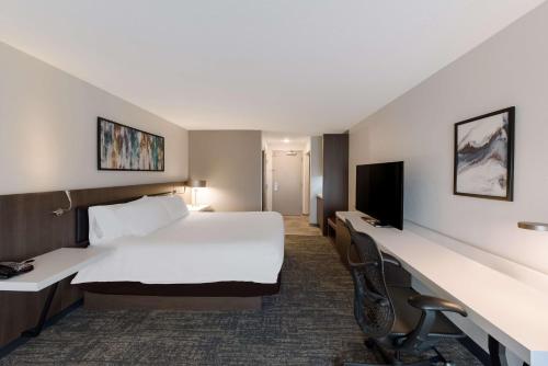 a hotel room with a bed and a flat screen tv at Hilton Garden Inn Columbus/Grove City in Grove City