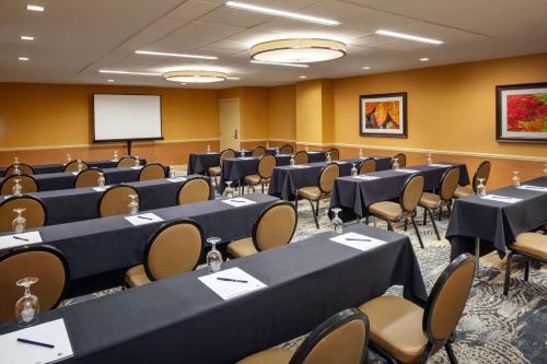 a conference room with tables and chairs and a whiteboard at DoubleTree Boston North Shore Danvers in Danvers