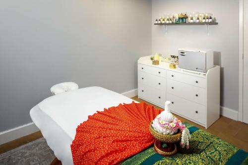 a small bedroom with a bed and a dresser at DoubleTree Boston North Shore Danvers in Danvers