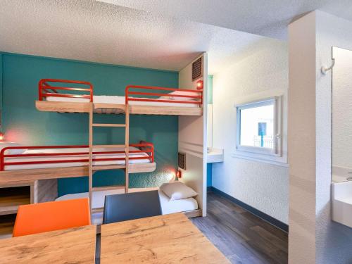a room with bunk beds and a table and chairs at hotelF1 Montpellier Est Vendargues in Vendargues