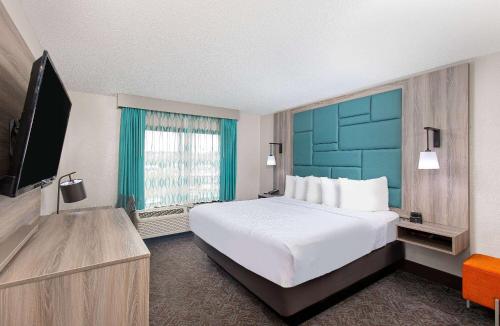 a hotel room with a large bed and a flat screen tv at La Quinta Inn by Wyndham Pigeon Forge-Dollywood in Pigeon Forge