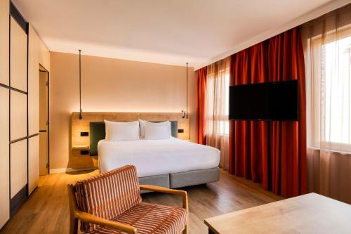 une chambre d'hôtel avec un lit et une chaise dans l'établissement Hilton Garden Inn Brussels City Centre, à Bruxelles