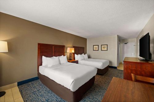a hotel room with two beds and a flat screen tv at Comfort Inn On the Ocean in Kill Devil Hills