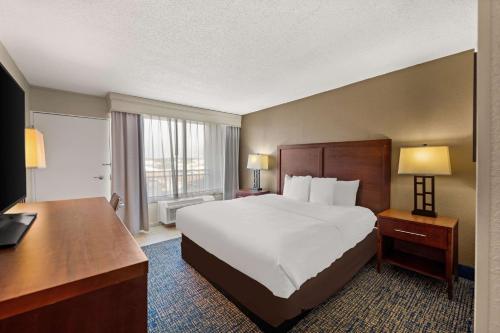 a hotel room with a large bed and a desk at Comfort Inn On the Ocean in Kill Devil Hills
