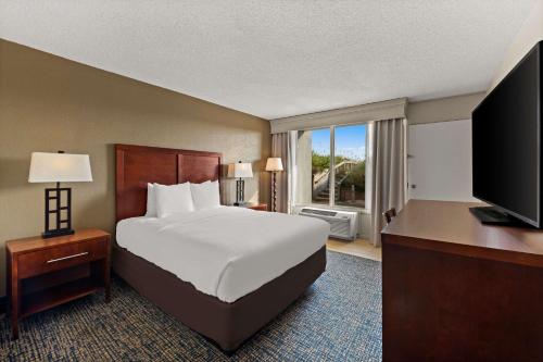 a hotel room with a bed and a television at Comfort Inn On the Ocean in Kill Devil Hills