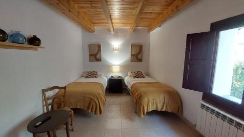 2 Einzelbetten in einem Zimmer mit Fenster in der Unterkunft Casa Castan in Lirí