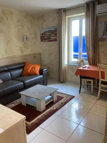 a living room with a couch and a table at Appartement « Athènes » à Avignon in Avignon