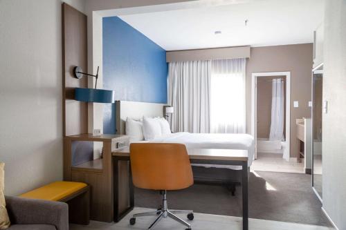 a bedroom with a bed and a desk with a chair at Comfort Suites Baton Rouge South I-10 in Baton Rouge
