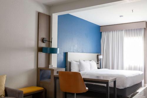 a hotel room with a bed and a desk and a chair at Comfort Suites Medical District near Mall of Louisiana in Baton Rouge