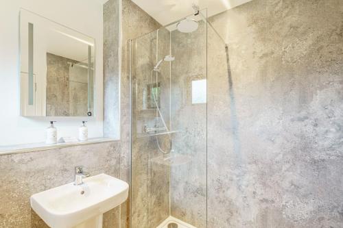 a bathroom with a sink and a glass shower at Birch Lodge 23 with Hot Tub in Newton Stewart