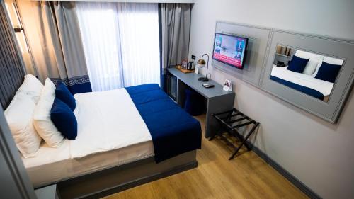 um quarto com uma cama, uma secretária e uma televisão em Elina Managed by Dedeman em Atakum