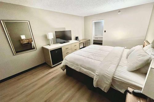 a hotel room with a bed and a television at Super 8 by Wyndham Blythe in Blythe