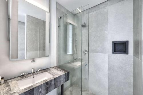 y baño con ducha acristalada y lavamanos. en The Bogart by LuxUrban, Trademark Collection by Wyndham, en Brooklyn