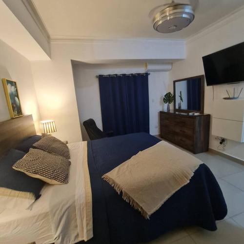 1 dormitorio con 1 cama y TV en Apartamento completo en Bella vista 1 o 2 dormitorios, en Santo Domingo