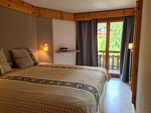 1 dormitorio con 2 camas y ventana grande en Appartement Bristol Villars-sur-Ollon en Villars-sur-Ollon