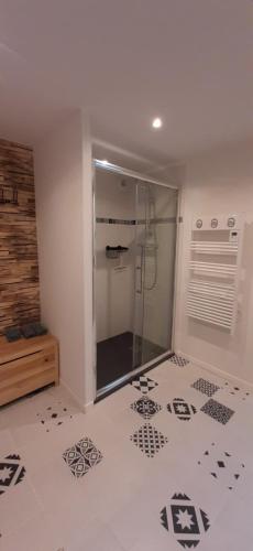 a bathroom with a shower and a tile floor at Le Clos Macé - Maison d'hôtes de charme au cœur des châteaux in Saint-Denis-sur-Loire