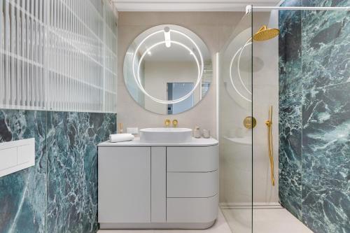 a bathroom with a sink and a mirror at Grand Apartments Chlebova in Gdańsk