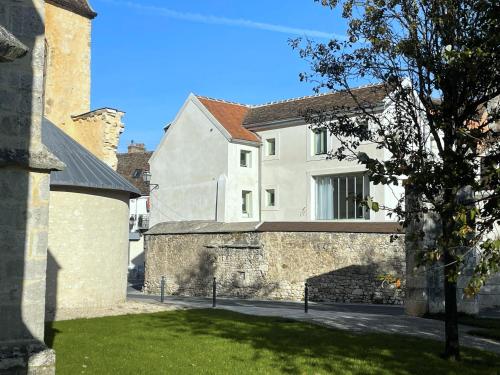 a building with a wall and a tree in a yard at Place Sainte Marguerite in Provins