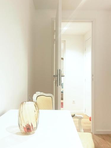 a white bedroom with a white bed and a chair at Place Sainte Marguerite in Provins