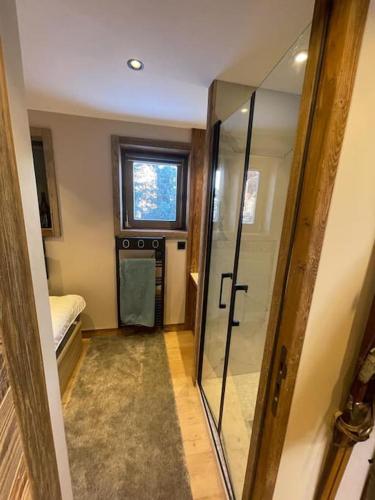 ein Badezimmer mit Glasdusche und Fenster in der Unterkunft Appartement centre megeve in Megève