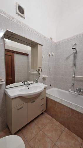 a bathroom with a sink and a tub and a mirror at The Crazy House in Catania