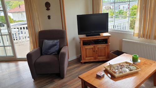a living room with a chair and a television at Chalet 128 Krabbenkreek in Sint Annaland
