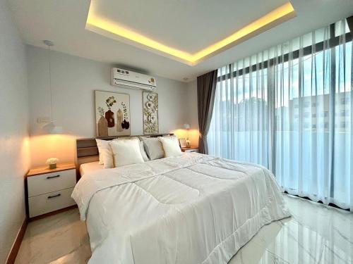 - une chambre avec un lit blanc et une grande fenêtre dans l'établissement Modern Mountain View, à Chiang Mai